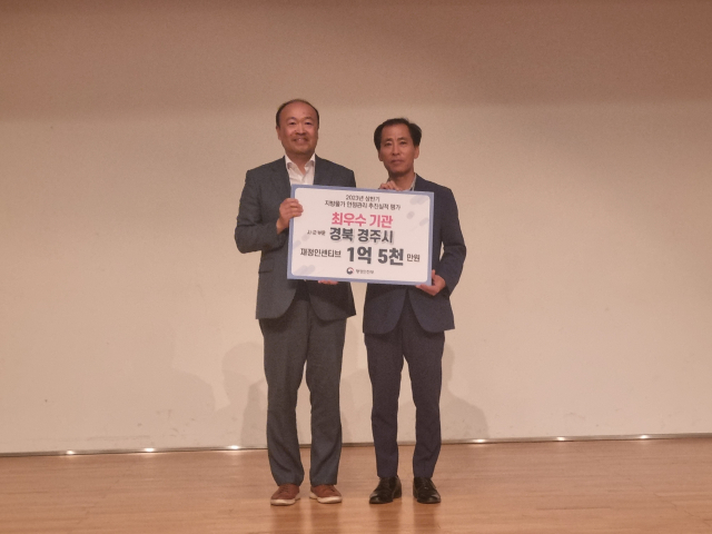 황훈(오른쪽) 경주시 경제정책과장이 12일 경북대 글로벌플라자에서 열린 지역경제활성화 워크숍에 참석해 지방물가 안정관리 최우수기관 표창을 수상한 뒤 김태희 행정안전부 지역경제과장과 기념촬영을 하고 있다. 경주시 제공