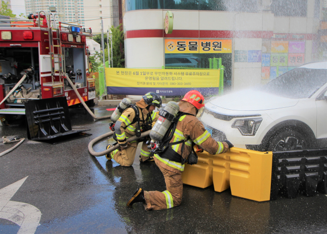 12일 오전 10시쯤 포항시 북구 한 마트 주차장에서 포항북부소방서 소방대원들이 전기차 화재 진화를 시연하고 있다. 포항북부소방서 제공.