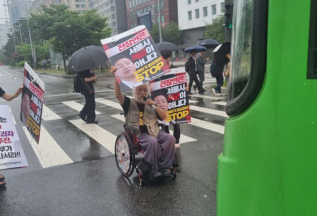 서울 영등포경찰서는 14일 차도를 막고 시위를 벌여 교통을 방해한 혐의로 박경석(63) 전국장애인차별철폐연대(전장연) 대표를 현행범으로 체포했다. 경찰은 이날 오후 2시10분께 서울 영등포구 여의도동 국회의사당역 인근 의사당대로에서 시위 중인 박 대표에게 업무방해와 도로교통법 위반 혐의로 체포한다고 고지했다. 사진은 시위를 벌이고 있는 박경석 대표. 연합뉴스