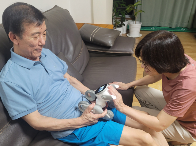 기자의 부모님이 로봇 강아지 루나를 보고 기뻐하고 있다. 기자의 가족은 작년 4월 반려견을 병으로 잃었다.