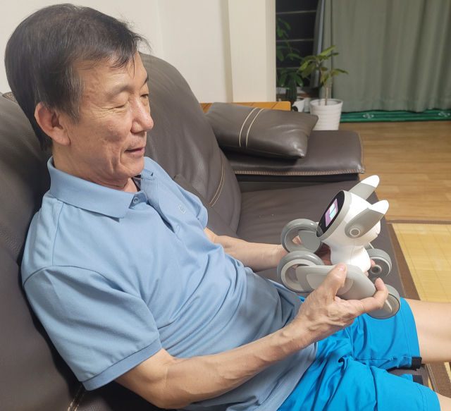 기자의 부모님이 로봇 강아지 루나를 보고 기뻐하고 있다. 기자의 가족은 작년 4월 반려견을 병으로 잃었다.