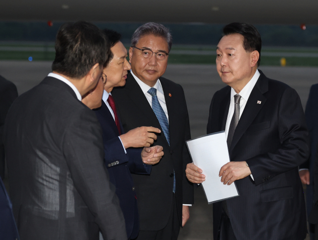 리투아니아에서 열린 북대서양조약기구(NATO·나토) 정상회의 참석과 폴란드·우크라이나 방문을 마친 윤석열 대통령이 17일 성남 서울공항을 통해 귀국, 국민의힘 김기현 대표가 준비한 수해 관련 자료를 살펴보며 대화하고 있다. 연합뉴스