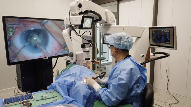 디지털 현미경 시스템을 통해 3차원 안경을 쓰고 모니터를 보면서 백내장 수술을 시행하는 모습. 아이백안과 제공