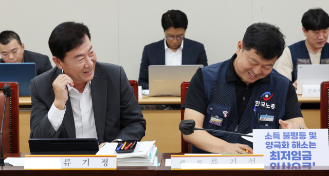 18일 오후 세종시 정부세종청사 최저임금위원회 회의실에서 열린 제14차 전원회의에서 사용자위원인 류기정 한국경영자총협회 전무(왼쪽)와 근로자위원인 류기섭 한국노총 사무총장이 대화하고 있다. 연합뉴스