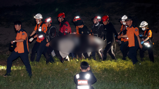 19일 밤 경북 예천군 호명면 고평교 인근에서 119구조대가 수색 중 실종된 해병 장병의 시신을 인양해 구급차로 이송하고 있다. 김영진 기자 kyjmaeil@imaeil.com