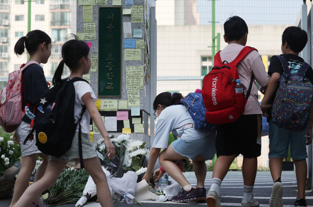 20일 오전 서초구 한 초등학교 앞에 등굣길 학생이 헌화를 하고 있다. 교육계에 따르면 이 학교 담임 교사 A씨가 학교 안에서 극단적 선택을 해 숨지는 일이 발생했다. 연합뉴스