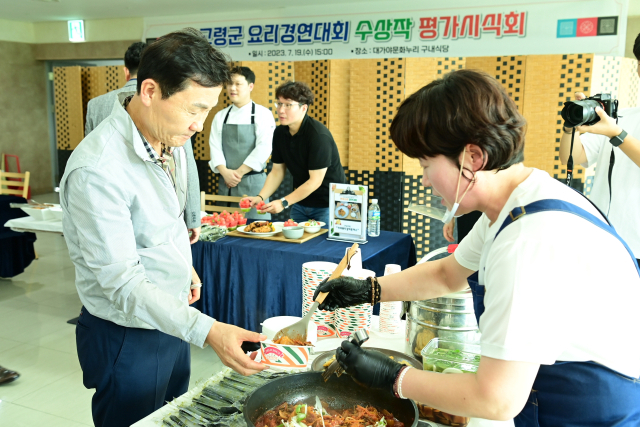 이남철(왼쪽) 고령군수가 고령군 주최 전국요리경연대회 수상 메뉴 평가시식회에서 음식을 받고 있다. 고령군 제공