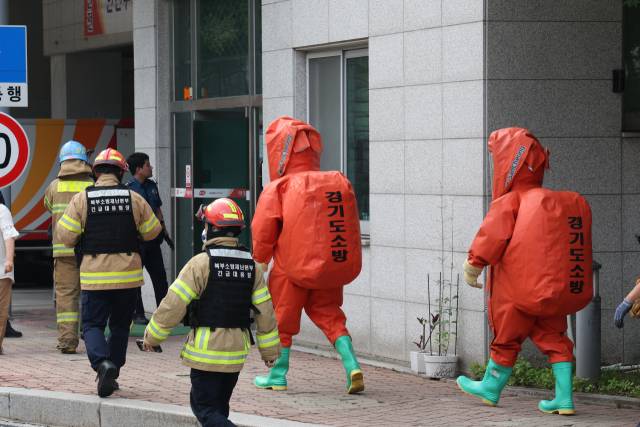 21일 경기도 의정부시 신곡동 의정부우체국에서 화학사고 보호의를 착용한 소방대원들이 건물 안으로 들어가고 있다. 이날 오후 의정부우체국에서 유해 물질로 의심되는 우편물이 발견됐다는 신고가 접수돼 경찰과 소방당국은 직원을 모두 대피시키고 조사를 벌였다. 연합뉴스