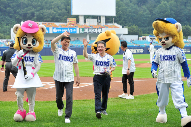 김진열(오른쪽) 대구시 군위군수와 박수현(왼쪽) 군위군의회 의장이 삼성리이온즈 홈 경기에 앞서 시구, 시타를 마치고 관중들에게 인사를 하고 있다. 군위군 제공