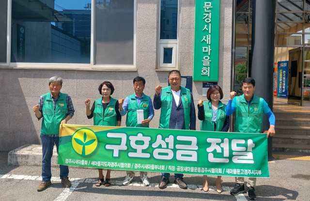 경주시새마을회 관계자들이 문경시새마을회를 방문해 수해 복구를 위해 모금한 성금을 전달한 뒤 파이팅을 외치고 있다. 경주시새마을회 제공
