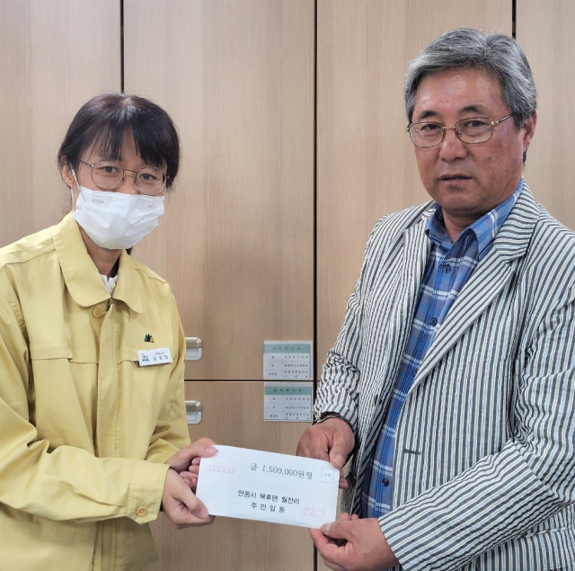 안동시 북후면 월전리 고창형(오른쪽) 이장이 예천군청을 찾아 성금 150만원을 전달하고 있다. 안동시 제공