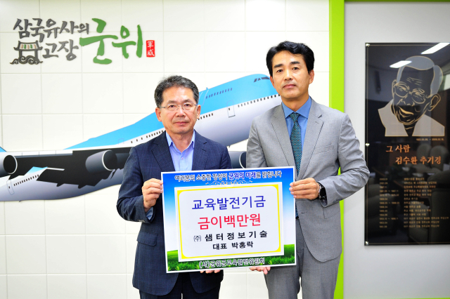 박홍락 ㈜샘터정보기술 대표가 대구 군위군에 교육발전기금을 기탁하고, 김진열 군위군수와 기념 사진을 촬영하고 있다. 군위군 제공