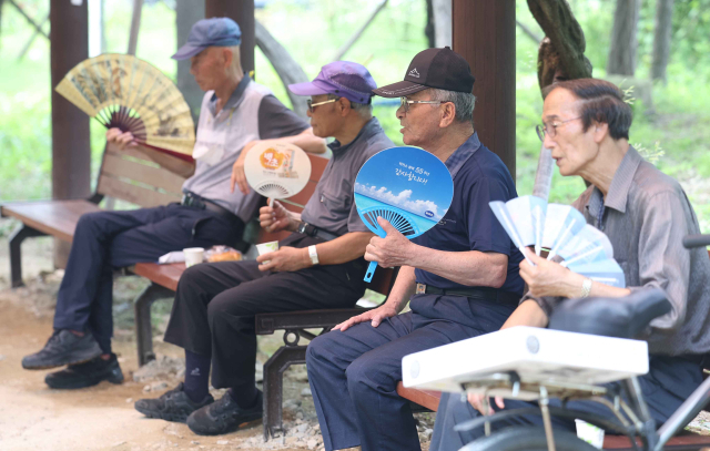 창원지역에 폭염경보가 발효된 26일 오후 경남 창원시 마산합포구 3·15해양누리공원에서 시민들이 부채질을 하며 더위를 식히고 있다. 연합뉴스