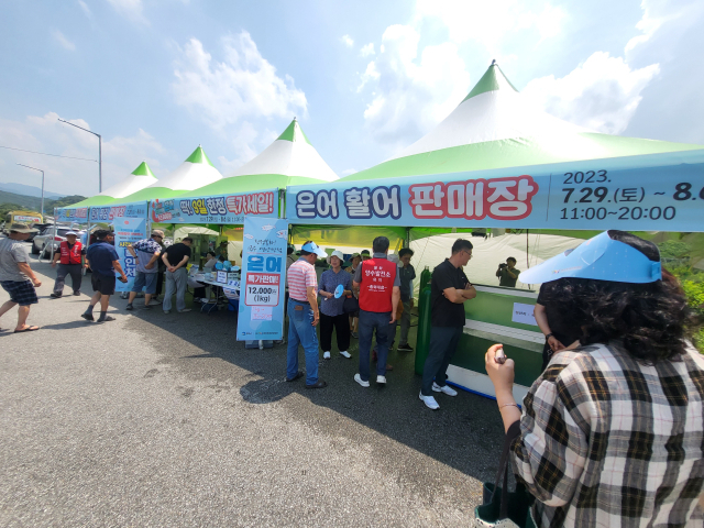 은어 활어 판매장을 찾은 관광객들이 은어를 구입하고 있다. 봉화군 제공