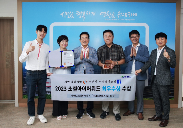 최기문(왼쪽 세 번째) 영천시장과 담당공무원 등이 소셜아이어워드 페이스북 분야 최우수상 수상을 축하하고 있다. 영천시 제공