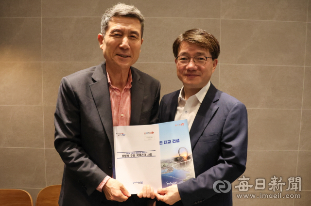 이강덕(왼쪽) 포항시장이 7일 김동일 기재부 예산실장을 만나 영일만대교 건설 등 지역 현안사업에 대한 국비 요청 설명자료를 건네고 있다. 포항시 제공