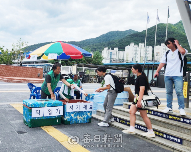 새마을지도자 경산시협의회가 7일 경산역에서 시민들에게 얼음 생수 나눔 봉사활동을 하고 있다. 새마을지도자 경산시협의회 제공