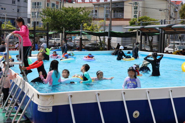 폭염이 기승을 부린 12일 제주시 도두동 오래물광장 일대에서 열린 도두 오래물 축제장에서 어린이들이 용천수를 채운 임시 풀장에서 물놀이하고 있다. 일 년 내내 차가운 물이 솟아나는 도두동의 용천수 