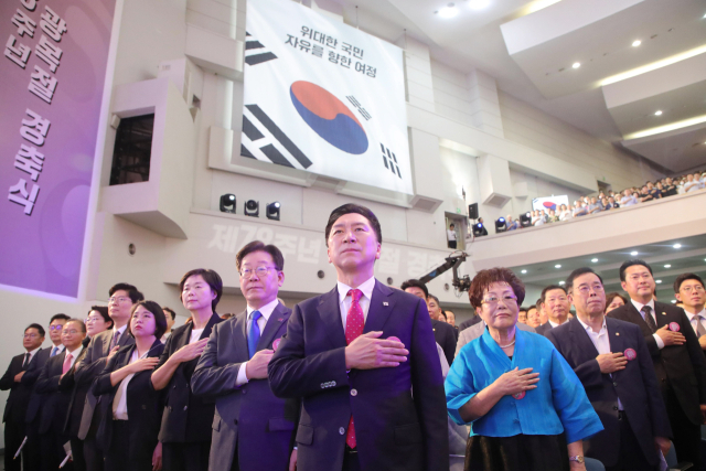 국민의힘 김기현 대표(가운데 부터 왼쪽으로), 더불어민주당 이재명 대표, 정의당 이정미 대표 등이 15일 서울 서대문구 이화여대 대강당에서 열린 제78주년 광복절 경축식에서 국기에 대한 경례를 하고 있다. 연합뉴스