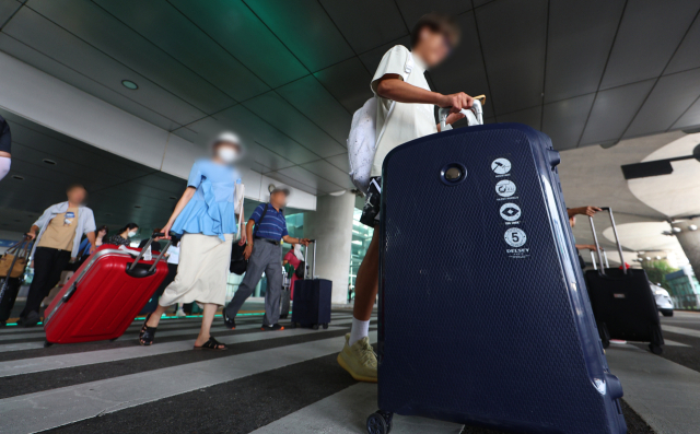 한국으로 단체 관광을 온 중국 단체 관광객들이 인천국제공항 제1여객터미널에서 버스 탑승장으로 이동하고 있다. 연합뉴스