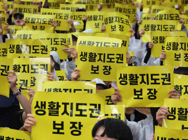 12일 서울 종각역 인근 도로에서 열린 제4차 안전한 교육 환경을 위한 법 개정 촉구 집회에서 참여한 교사 등이 손팻말을 들고 구호를 외치고 있다. 연합뉴스
