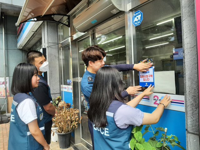 경북 칠곡경찰서와 청소년참여정책자문단이 무인점포 범죄예방 스티커를 부착하고 있다. 칠곡경찰서 제공
