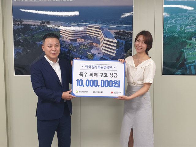 김범인(왼쪽) 한국원자력환경공단 대외협력팀장이 집중 호우로 피해를 본 경북 이재민을 위한 성금 1천만원을 경북도에 전달한 뒤 기념촬영을 하고 있다. 한국원자력환경공단 제공