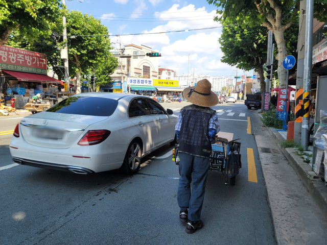 낮 최고기온이 34℃에 달했던 지난 15일 폐지를 줍는 노인이 칠성시장 일대를 다니고 있는 모습. 박성현 기자
