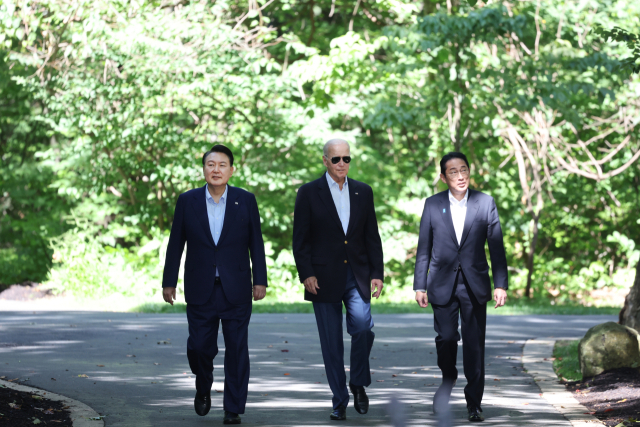 윤석열 대통령, 조 바이든 미국 대통령, 기시다 후미오 일본 총리가 18일(현지시간) 워싱턴DC 인근 미국 대통령 별장인 캠프 데이비드에서 한미일 정상 공동기자회견을 위해 오솔길을 함께 걸어 오고 있다. 연합뉴스