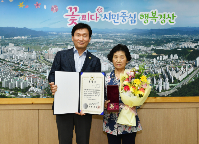 조현일 경산시장이 21일 6·25 전쟁에 참전해 공을 세운 고(故)박태술 상병의 자녀 박순연(오른쪽) 씨에게 화랑무공훈장과 증서를 전수했다.