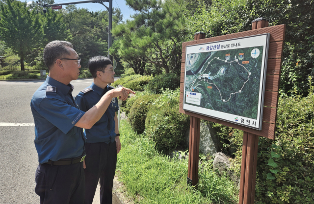영천경찰서 직원들이 금강산성 등산로 안내도를 살펴보며 범죄예방 활동 방안을 논의하고 있다. 영천경찰서 제공