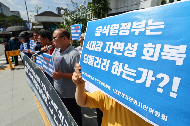 환경운동연합 회원들이 4일 오전 서울 종로구 정부서울청사 앞에서 열린 금강·영산강 보 처리방안 관련 국가물관리위원회 규탄 기자회견에서 팻말을 들고 있다. 이들은 금강·영산강 보 존치 결정은 수문 개방 이후 재자연화가 이루어지고 있는 강들의 자연성 회복을 되돌리는 일이라고 주장했다. 연합뉴스