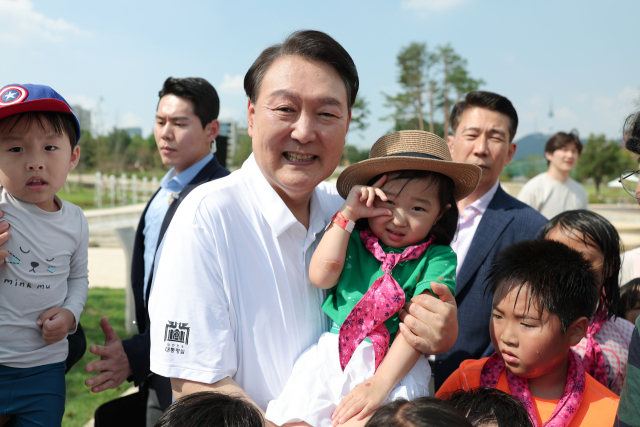 윤석열 대통령이 26일 서울 용산어린이정원 내 조성된 분수정원에서 열린 다둥이가족 초청행사에 깜짝 방문, 어린이들과 기념사진을 찍고 있다. 연합뉴스