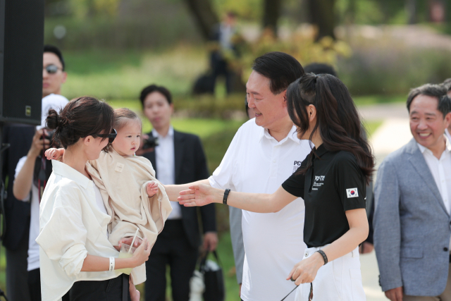 윤석열 대통령과 김건희 여사가 26일 서울 용산어린이정원 내 조성된 분수정원에서 열린 다둥이가족 초청행사에 깜짝 방문, 어린이와 인사를 나누고 있다. 연합뉴스