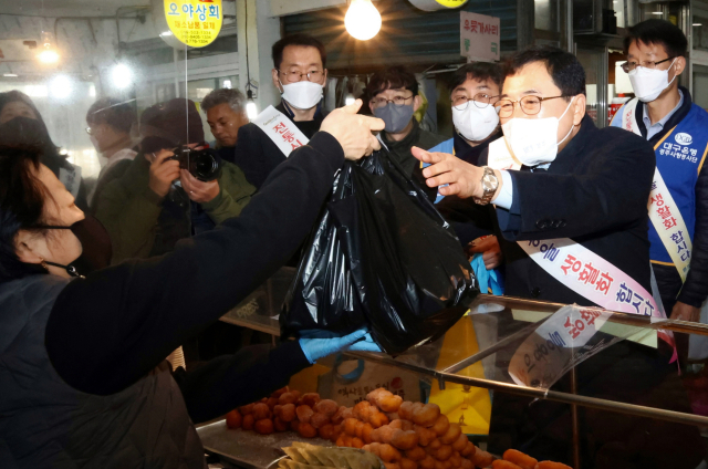 지난 1월 설을 앞두고 전통시장 장보기 행사에 참여한 주낙영 경주시장이 지역 한 시장에서 물건을 구입하고 있다. 경주시 제공