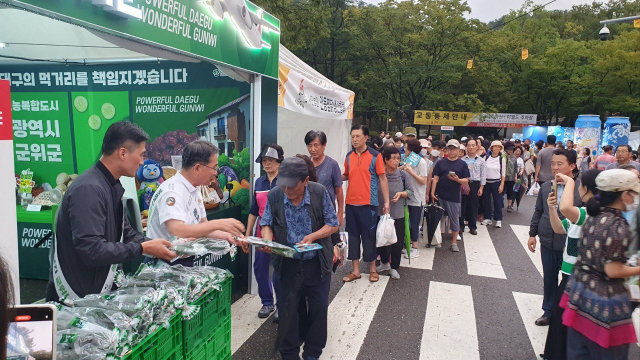 김진열 군위군수와 직원들이 대구치맥페스티벌 개막식에서 대구시민들에게 군위군의 농특산품인 가시오이를 홍보하고 있다. 군위군 제공
