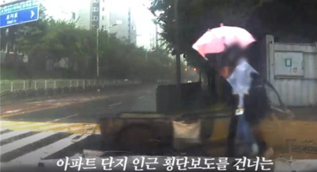 비가 오는 날 폐지를 주워 손수레를 밀고 가던 노인에게 우산을 씌어준 한 여성의 모습이 알려져 사회에 훈훈함을 낳고 있다. 연합뉴스TV 캡처