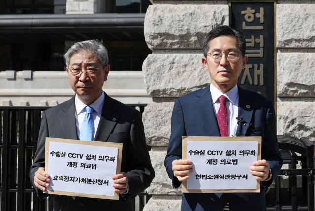 이필수 대한의사협회 회장(오른쪽)과 윤동섭 대한병원협회 회장이 5일 오전 서울 종로구 헌법재판소에 수술실 CCTV 설치 의무 법제화 헌법소원 청구서를 제출하기 전 청구서를 들어보이고 있다. 연합뉴스