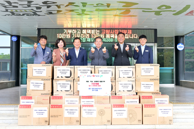 천주교 대구대교구 김수환 추기경 사랑과 나눔공원 이정욱(안드레아) 신부가 교구 신자들의 정성으로 마련한 가전제품을 군위군에 기탁하고, 김진열 군위군수와 기념 사진을 촬영하고 있다. 군위군 제공