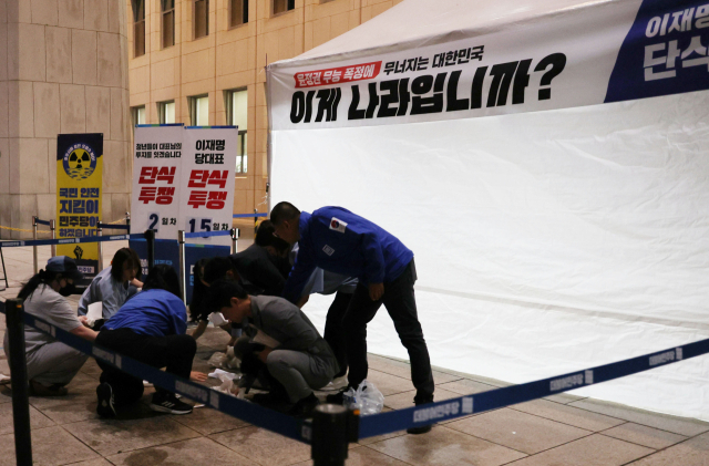 14일 국회 본청 앞에 설치된 더불어민주당 단식 농성장에서 한 시민이 휘두른 흉기에 경찰이 다치는 사건이 발생했다. 국회와 당 관계자들이 사건 현장을 정리하고 있다. 연합뉴스