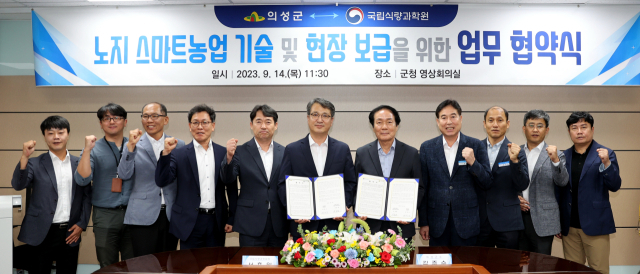 의성군과 국립식량과학원이 노지 스마트농업 기술 및 현장 보급을 위한 업무협약 후 기념촬영을 하고 있다. 의성군 제공