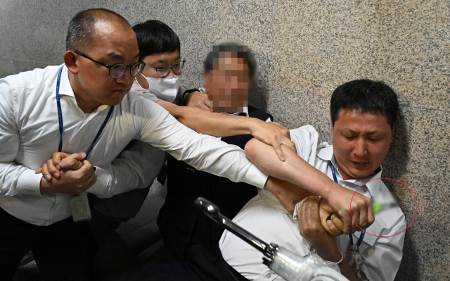 15일 더불어민주당 이재명 대표가 단식 중인 국회 당대표실 앞에서 국회 직원들이 혈서를 쓴다며 커터칼(오른쪽 아래 붉은 원)을 든 시민을 제지하고 있다. 연합뉴스