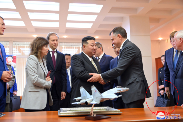김정은 북한 국무위원장이 지난 15일 러시아 하바롭스크주 콤소몰스크나아무레시의 유리 가가린 전투기 공장을 방문했다고 조선중앙통신이 16일 보도했다. 김 위원장의 여동생 김여정 노동당 부부장이 러시아 비행기 공장 방문 당시 들었던 가방(붉은 원)이 프랑스 고가·사치품 브랜드 