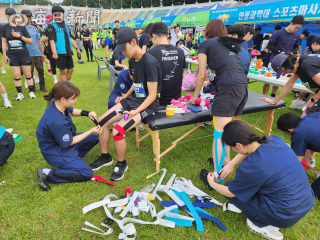 17일 안동과학대 스포츠마사지학과 학생들이 안동마라톤대회 참가자들에게 스포츠 마사지와 스포츠 테이핑 봉사를 하는 모습. 전종훈 기자