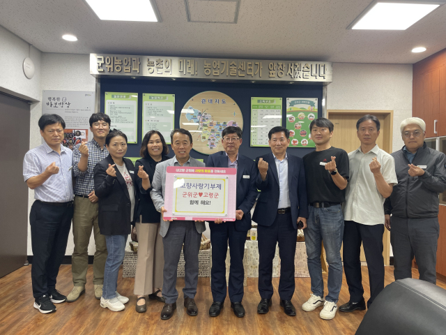 대구시 군위군농업기술센터와 경북 고령군농업기술센터가 고향사랑기부제에 상호 기부하고, 기념 사진을 촬영하고 있다. 군위군 제공