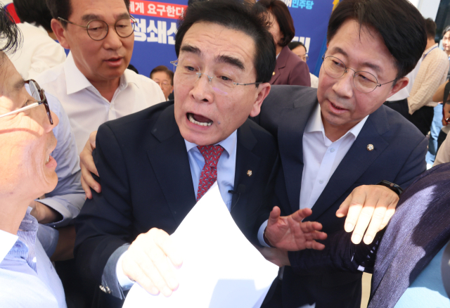 국민의힘 태영호 의원이 7일 단식 투쟁 중인 더불어민주당 이재명 대표의 국회 앞 천막에서 조정식 사무총장 등 의원들의 요구로 발걸음을 돌리고 있다. 태 의원은 전날 본회의장 야당 의원들의 발언에 항의하기 위해 이재명 대표를 찾았다. 연합뉴스