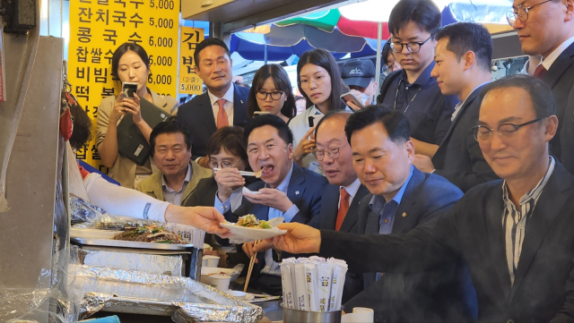 국민의힘 김기현 대표가 22일 서문시장을 방문, 국민의힘 국회의원과 함께 떡볶이를 먹고 있다.