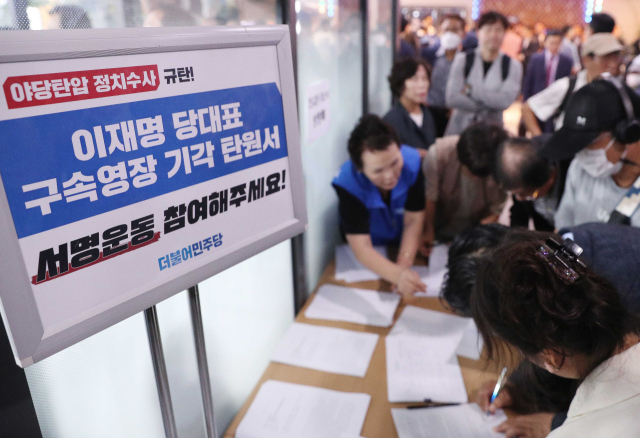 24일 진교훈 더불어민주당 강서구청장 후보자 선거사무소 개소식에서 민주당 지지자들이 이재명 대표 구속영장 기각 탄원서에 서명하고 있다. 연합뉴스