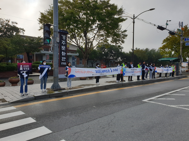 ㈜새천년미소 임직원들이 27일 오전 경주 성동시장‧중앙시장 앞에서 교통안전 캠페인과 