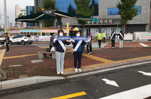 ㈜새천년미소 임직원들이 27일 오전 경주 성동시장‧중앙시장 앞에서 교통안전 캠페인과